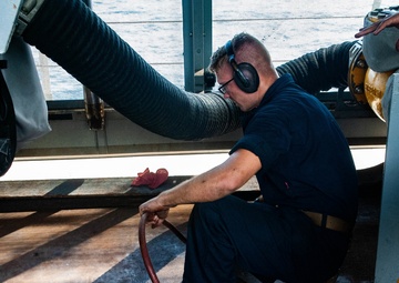 Builder 3rd Class Anthony Pugh with Naval Mobile Construction Battalion (NMCB) 4, performs preservation on a Fuel Station Deck aboard the USS New Orleans (LPD-18).