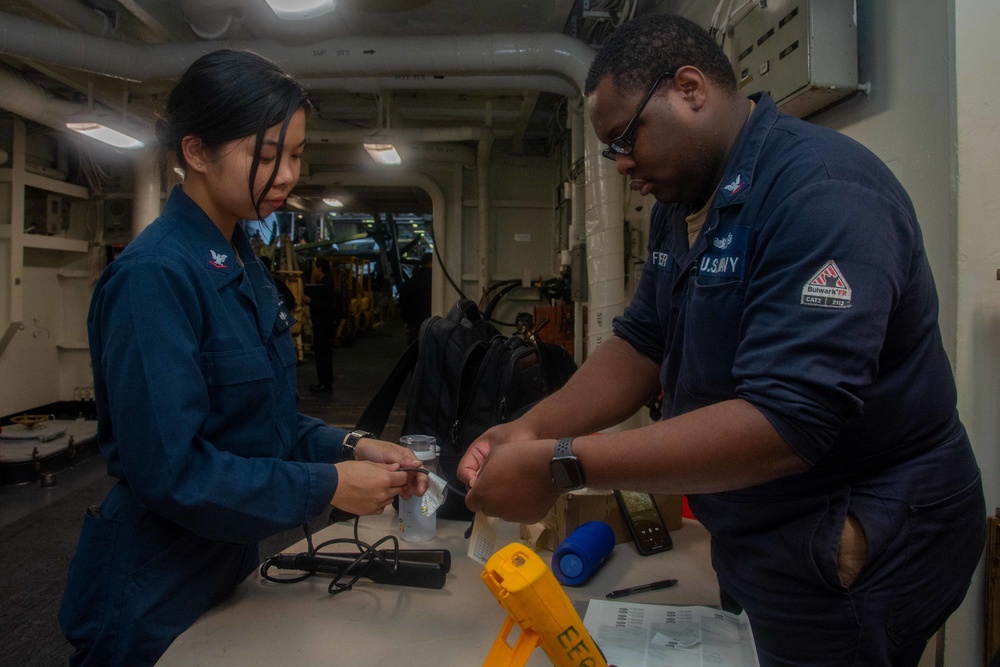 USS Ronald Reagan (CVN 76) Sailors in the AIMD tunnel and hangar bay