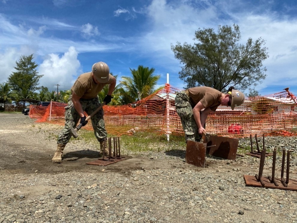 Seabees break through old welds on steel plate to repurpose them to be welded to the bottom of the new living units at Camp Katuu.