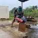 Steel Worker 3rd class Adam Steeves uses a rescue saw to cut through old welds on steel plate to repurpose them.