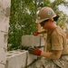 Steel Worker 3rd Class Kacianne Mcdaniel, lays a course of Concrete Masonry Units block.