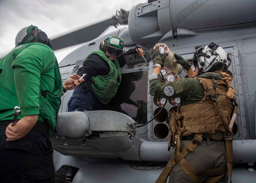 U.S. Sailors Load Radar Equipment Into An MH-60R Sea Hawk Helicopter