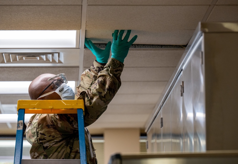 Air Force Mortuary Affairs Operations departures specialist replaces a ceiling tile