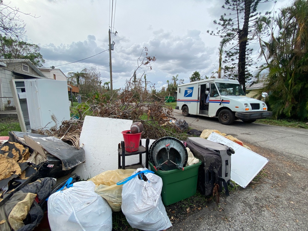 A US Postal Truck Delivers Mail in a Neighborhood Impacted by Hurricane Ian