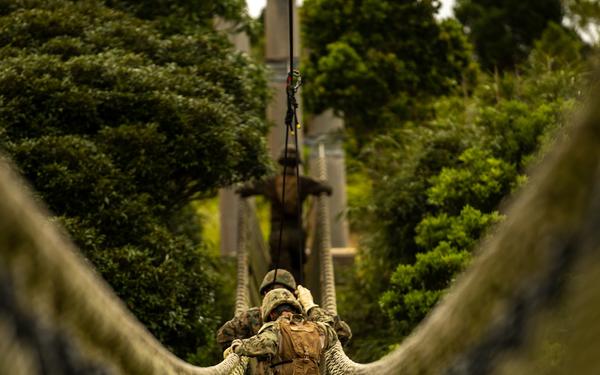 Seabees cross rope bridge during Jungle Warfare Training.
