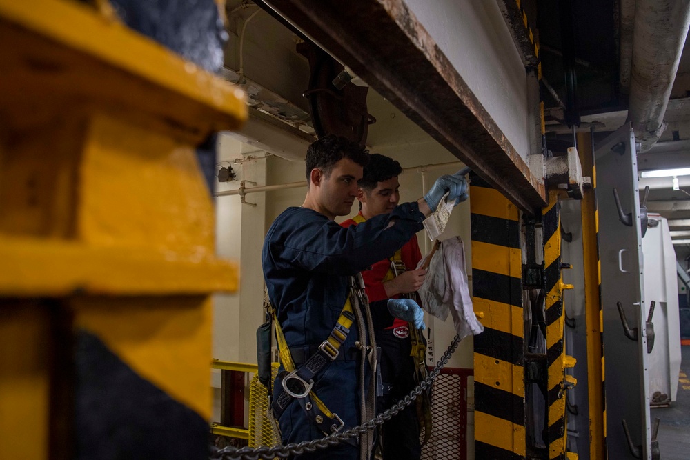 U.S. Navy Sailors Lubricate Weapons Elevator