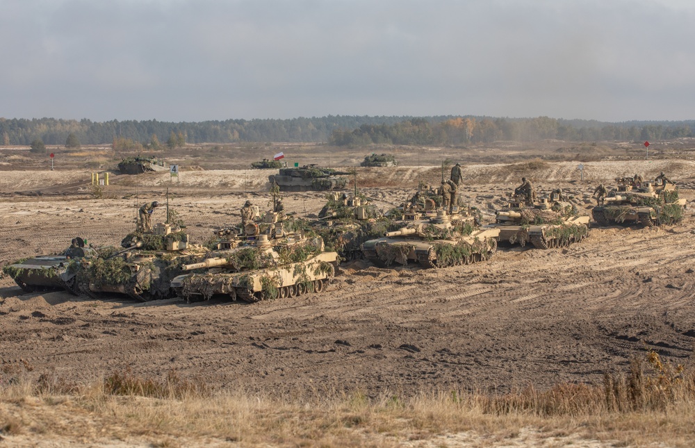 U.S. and Polish Armies maneuver tanks during live fire in Nowa Deba