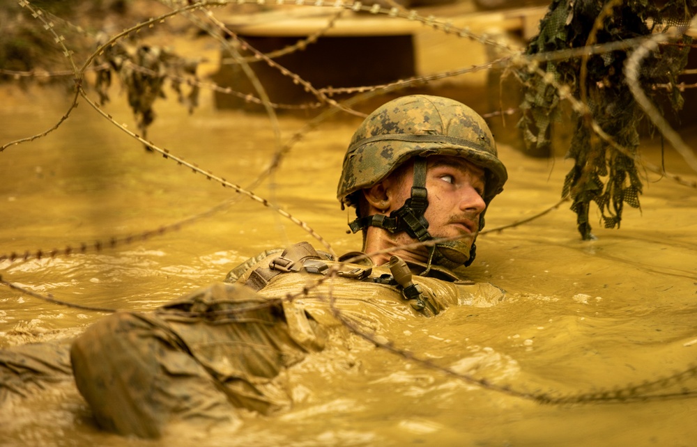 Construtionman Jessie Bryan maneuvers his way through the mud pits of Japans Jungle Warfare Training E-Course.