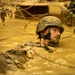 Construtionman Jessie Bryan maneuvers his way through the mud pits of Japans Jungle Warfare Training E-Course.