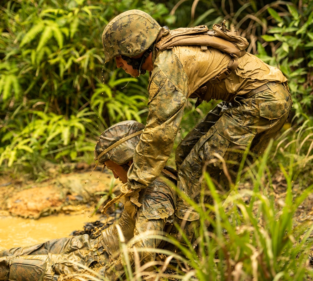 Builder Construtionman Hunter Haslip, pulls a Marine out of the final stage of the E-Course in Okinawa Japan.