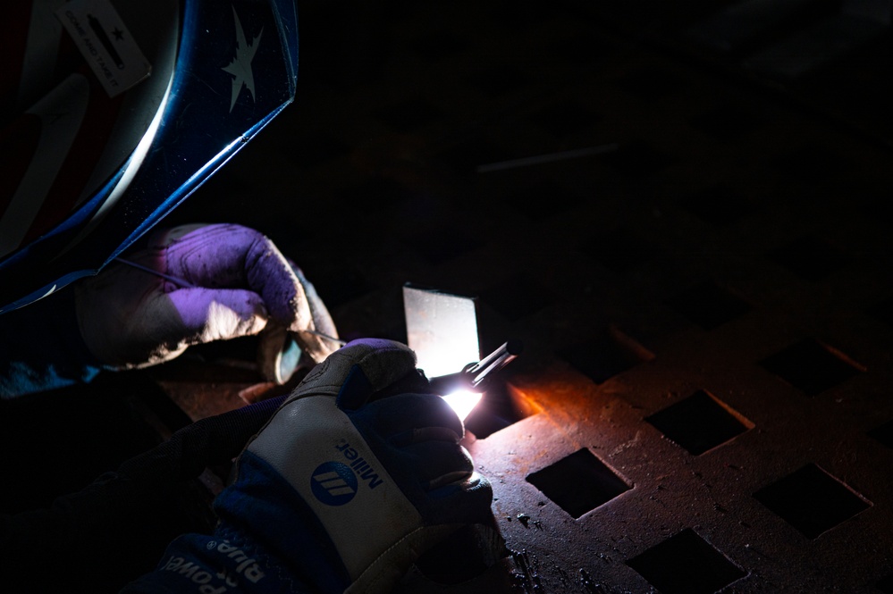 Coast Guard Cutter Hamilton crewmember welds while underway in the Atlantic Ocean