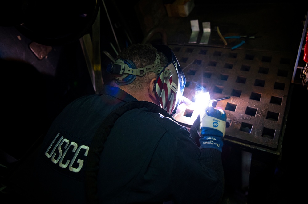 Coast Guard Cutter Hamilton crewmember welds while underway in the Atlantic Ocean