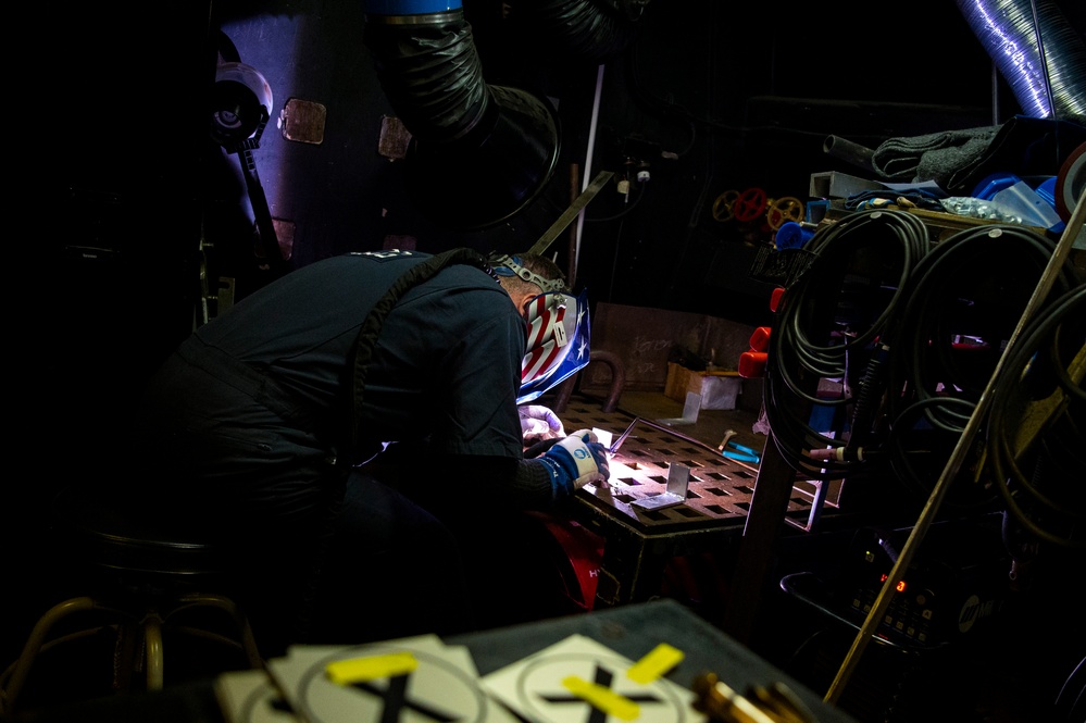 Coast Guard Cutter Hamilton crewmember welds while underway in the Atlantic Ocean