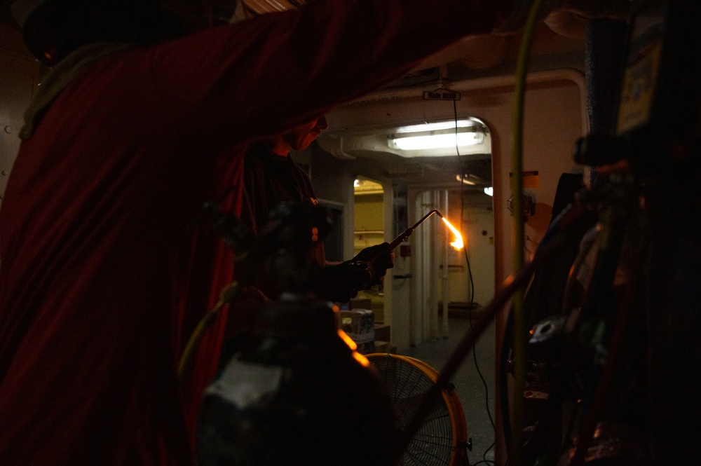 Coast Guard Cutter Hamliton crewmembers repair refrigerator while underway in the Atlantic Ocean