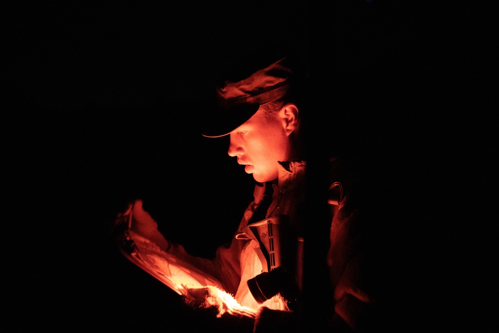Soldier reviews his map during night land navigation