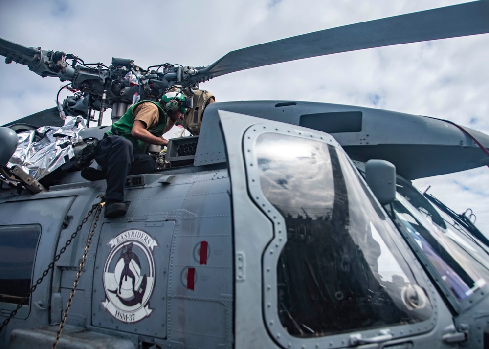 U.S. Sailor Performs Maintenance On An MH-60R Sea Hawk Helicopter