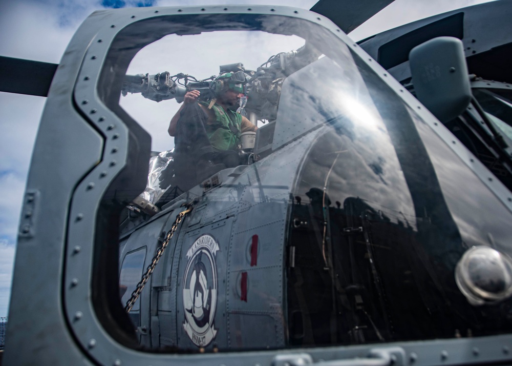 U.S. Sailor Performs Maintenance On An MH-60R Sea Hawk Helicopter