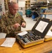 Photo of U.S. Air Force Tech. Sgt. Kurt Stuckart performing an annual inventory and inspection on a pin removal and insertion kit