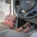 Photo of U.S. Air Force Tech. Sgt. Michael Moody installing a vehicle analytics device