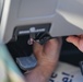 Photo of U.S. Air Force Tech. Sgt. Michael Moody installing a vehicle analytics device