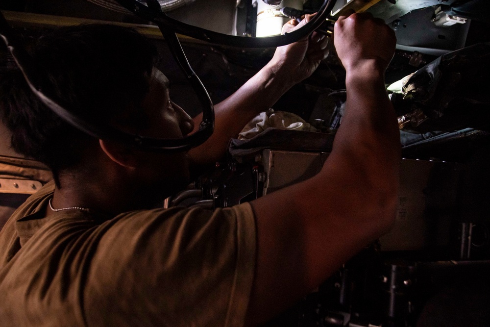 U.S. Sailor Performs Maintenance On An MH-60R Sea Hawk Helicopter