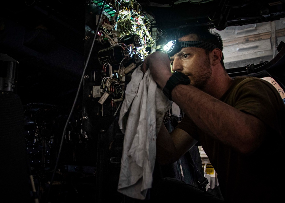 U.S. Sailor Performs Maintenance On An MH-60R Sea Hawk Helicopter