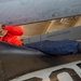 Sailor Removes Bolts From Aircraft