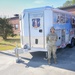 Photo of 116th Services Airman by disaster relief mobile kitchen trailer