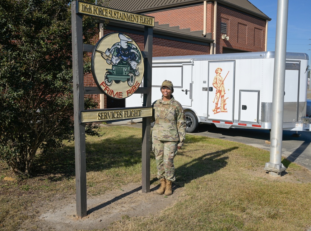 Photo of 116th Services Airman by disaster relief mobile kitchen trailer