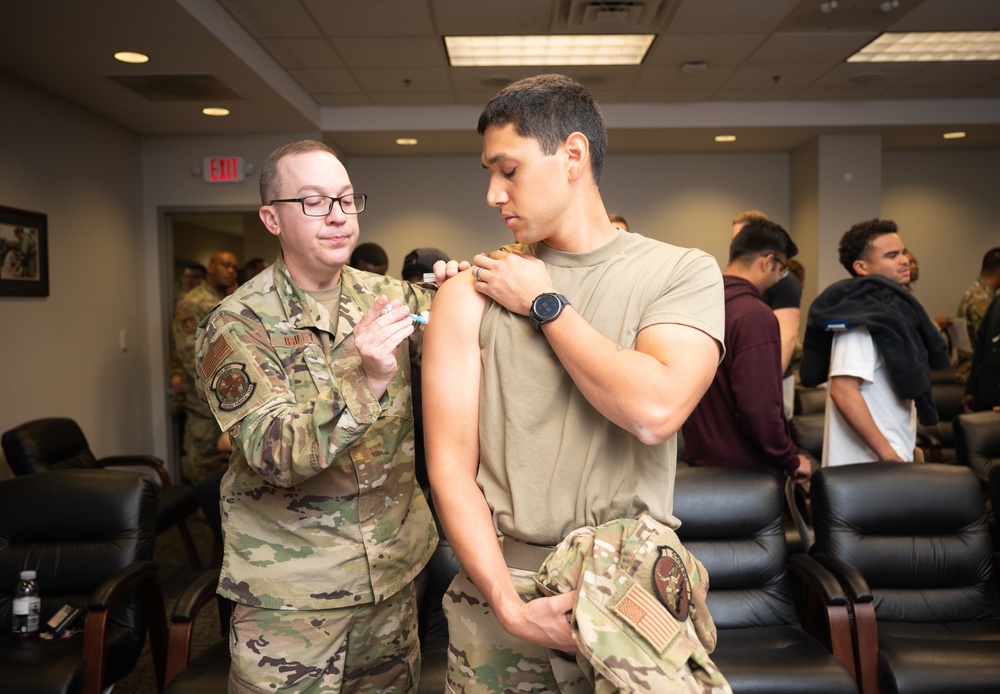 Photo of 116th Medical Group Airman administering flu vaccination to wing members