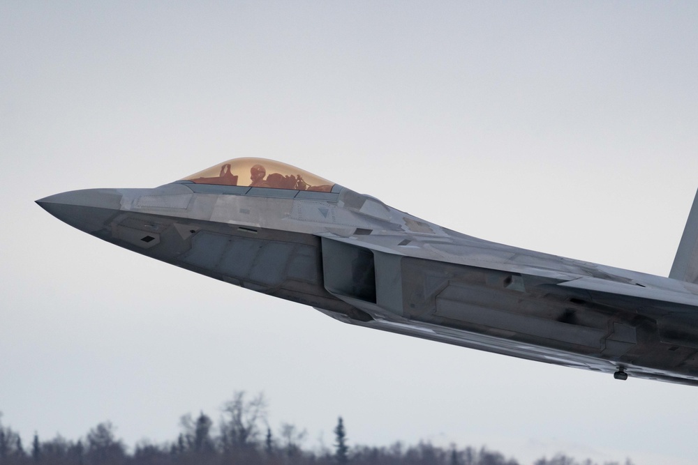 F-22s and HH-60Gs fly over JBER