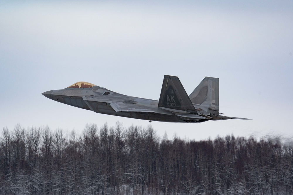 F-22s and HH-60Gs fly over JBER