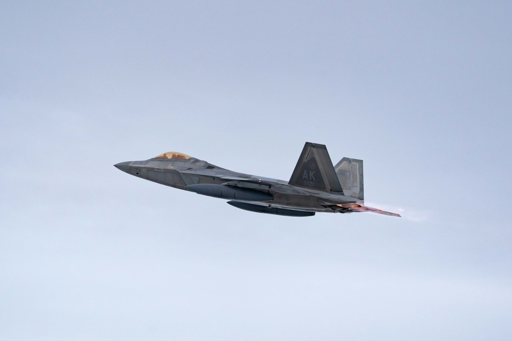 F-22s and HH-60Gs fly over JBER