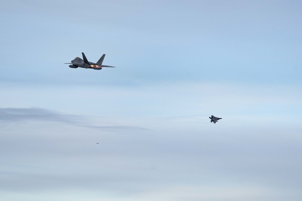 F-22s and HH-60Gs fly over JBER