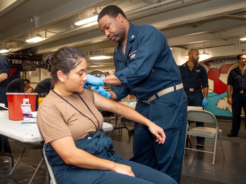 USS Ronald Reagan (CVN 76) Sailors administer and receive flu shots and blood tests