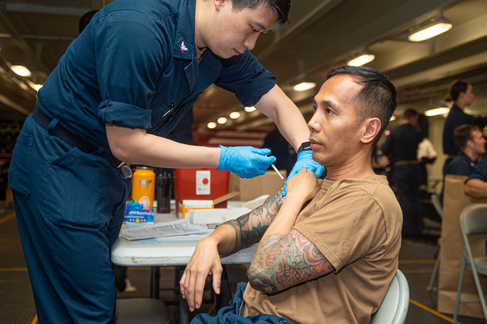 USS Ronald Reagan (CVN 76) Sailors administer and receive flu shots and blood tests