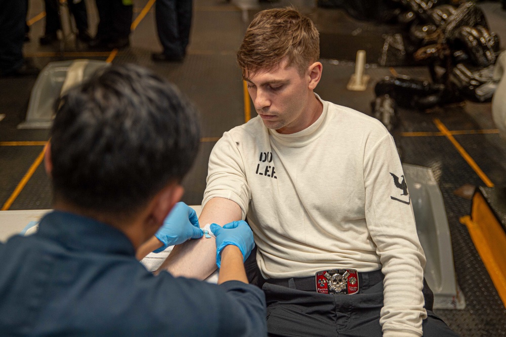 USS Ronald Reagan (CVN 76) Sailors administer and receive flu shots and blood tests