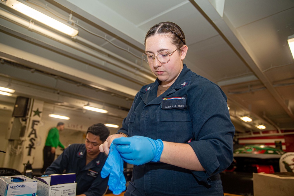 USS Ronald Reagan (CVN 76) Sailors administer and receive flu shots and blood tests