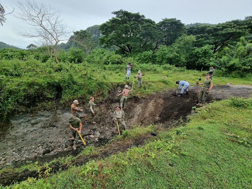 Seabees with Naval Moblie Construction Battalion 4, Mariens with 31st Marine Expeditionary Unit come together with Filipino Seabees in leveling out a small access path in Crow Valley.