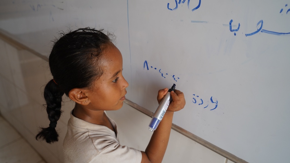 A girl student learns to write in Yemen