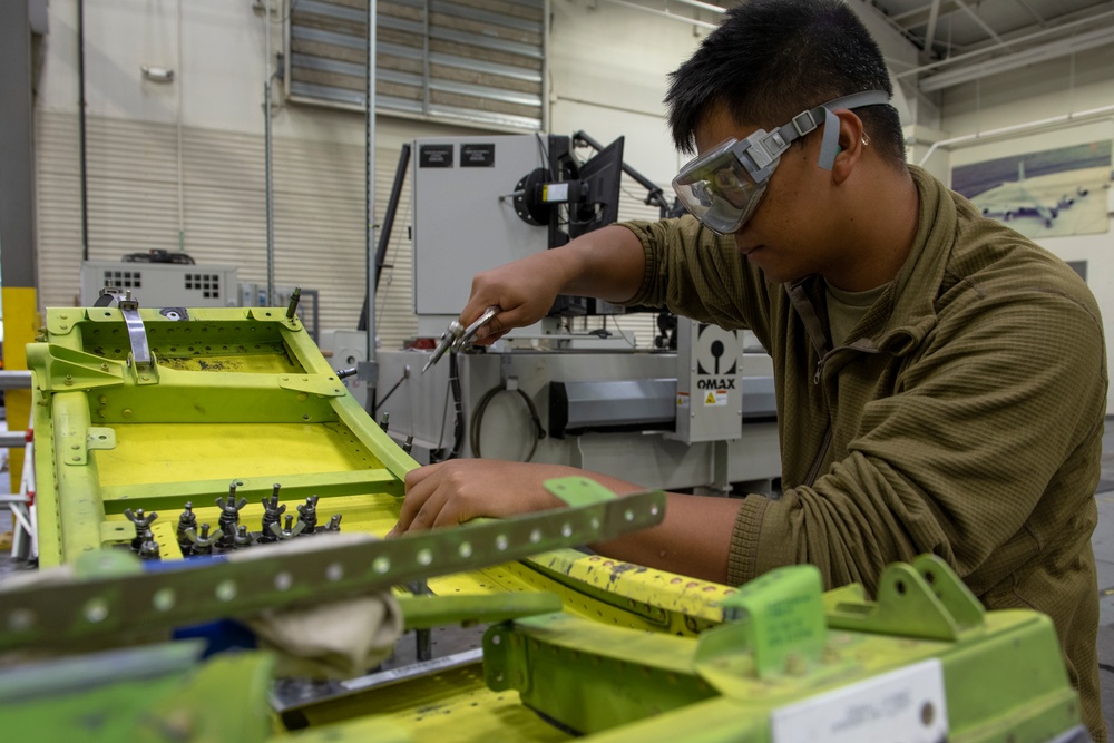 Maintenance Airmen repair APU doors