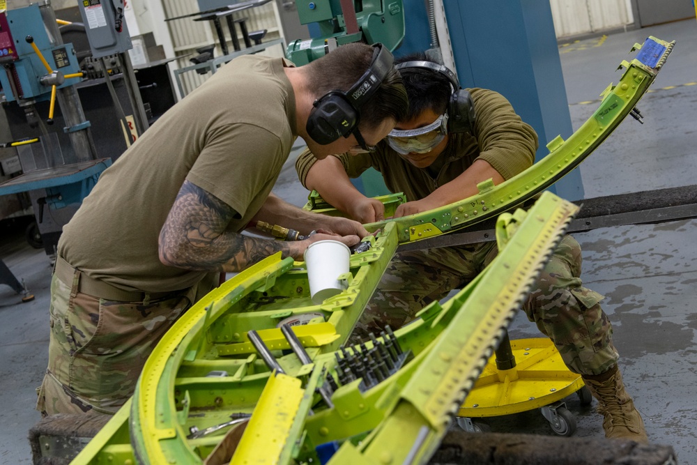 Maintenance Airmen repair APU doors