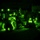 TACP Lightning Challenge 2022 A night vision image showing multiple military personnel conducting what appears to be a nighttime field operation or training exercise. The characteristic green monochrome imagery is captured through night vision optics, indicated by the circular vignette framing. Several personnel are visible wearing helmets equipped with IR (infrared) marker lights, which appear as bright glowing orbs.