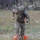 TACP Lightning Challenge 2022 A U.S. military soldier in full multicam combat gear is running or moving quickly across a grassy field during what appears to be a training exercise. The soldier is wearing a tactical helmet with communications equipment, a plate carrier vest with a U.S. flag patch, and is stepping over or near orange training markers on the ground. A Texas state flag patch is visible on the left shoulder, suggesting affiliation with the Texas National Guard.