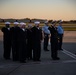 Sailors salute an aircraft containing the remains of RM3 Charles Montgomery.