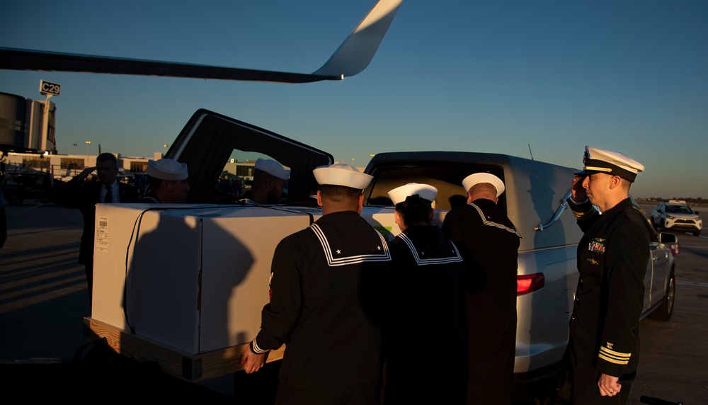 Sailors transfer the remains of Radioman 3rd Class Charles A. Montgomery into a hearse bound for his final resting place.