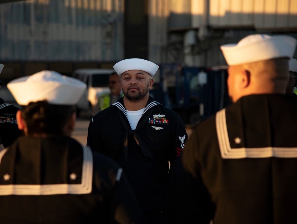 Sailors prepare to receive the remains during the dignified transfer of remains of Radioman 3rd Class Charles A. Montgomery.