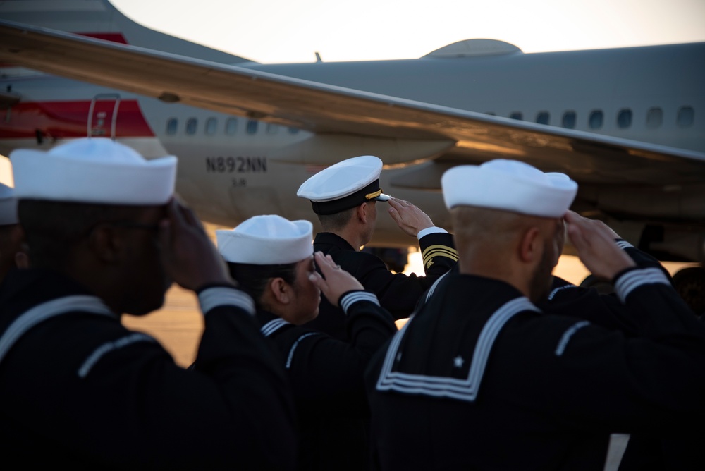 Sailors render a salute during the dignified transfer of remains of Radioman 3rd Class Charles A. Montgomery.