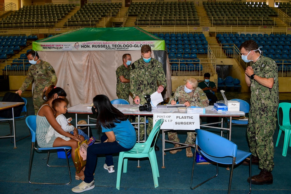 U.S. Navy and Air Force medical professionals conduct post operation check-ups