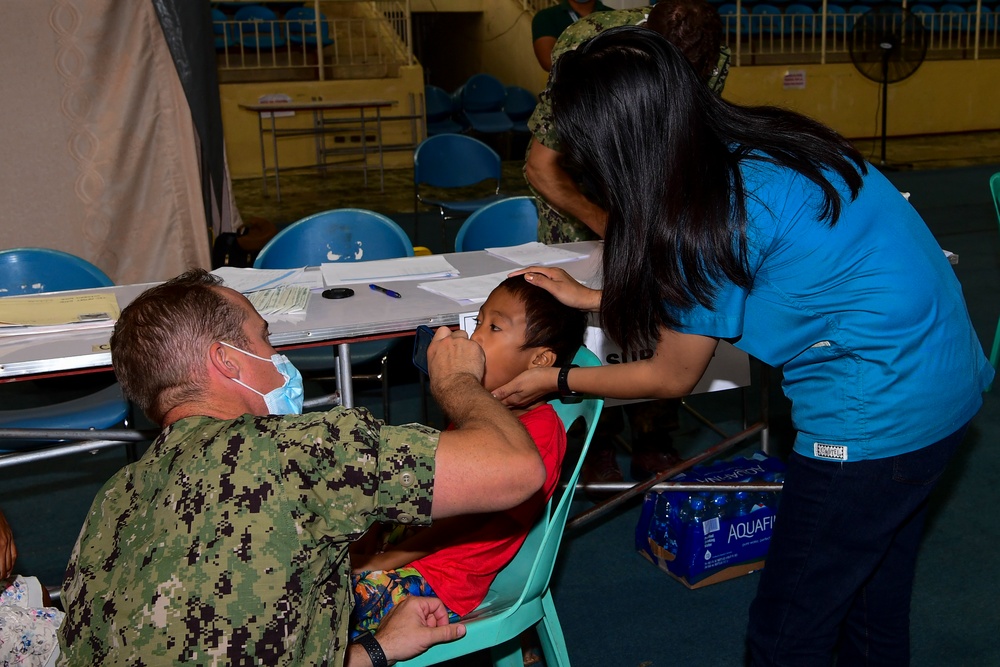 U.S. Navy and Air Force medical professionals conduct post operation check-ups
